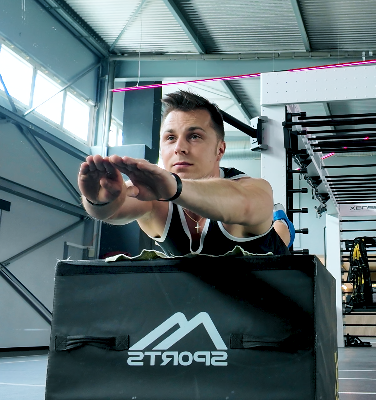 EVENI-Coach beim Training mit nach vorn ausgestreckten Armen im Fitnessstudio